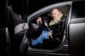 Male driver in a leather jacket in the car in the dark time. Night unusual photo shoot. Night photo shoot