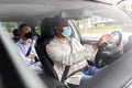 male driver in mask driving car with passenger Royalty Free Stock Photo