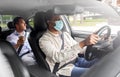male driver in mask driving car with passenger Royalty Free Stock Photo