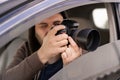 Male driver photographing with slr camera from car, Private detective taking photos Royalty Free Stock Photo