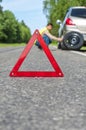 Male driver in reflective vest changing the tire Royalty Free Stock Photo