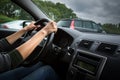 Male driver`s hands driving a car on a highway