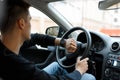 Male driver sitting in car in traffic jam and looking at clock. Royalty Free Stock Photo