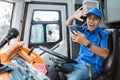 a male driver in uniform looks at his cellphone with an expression that crashes Royalty Free Stock Photo