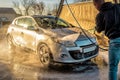 Male driver washing his car with contactless high pressure water jet in self service car wash Royalty Free Stock Photo