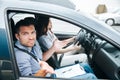 Male driving instructor shrugs up and looks at camera. Man doesn`t understand what his female student is doing Royalty Free Stock Photo