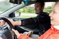 Driving instructor urgently helps the student make a turn
