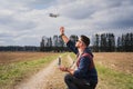 A male drone operator launches a quadcopter in nature