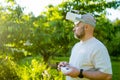 Male drone pilot operating tiny whoop FPV drone in the back yard. FPV experience with FPV glasses during sunset time