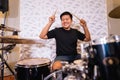 a male drummer holding drumsticks while playing drums with a band