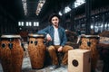 Male drummer pose against african wooden drum