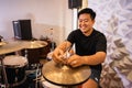 a male drummer prepares hi-hat cymbals before being used