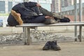 Male drunk beggar sleeping on bus stop