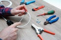 A male electrician changes the plug on an electric wire. Working with electrical tools. Stripper, crimp, screwdriver, wire cutters Royalty Free Stock Photo