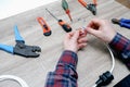 A male electrician changes the plug on an electric wire. Working with electrical tools. Stripper, crimp, screwdriver, wire cutters Royalty Free Stock Photo