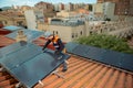 Male electrician engineer installing photovoltaic Solar Panels on city rooftop Royalty Free Stock Photo