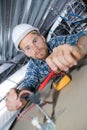 Male electrician fixing cables for light on ceiling Royalty Free Stock Photo