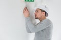 Male electrician fixing electric sign on ceiling