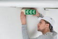 Male electrician fixing electric sign on ceiling Royalty Free Stock Photo