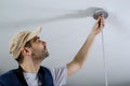 A male electrician fixing light on the ceiling. Royalty Free Stock Photo