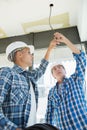 Male electrician fixing light on ceiling Royalty Free Stock Photo