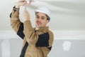 Male electrician fixing light on ceiling with screwdriver Royalty Free Stock Photo