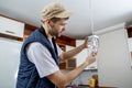 A male electrician fixing light on the ceiling. Royalty Free Stock Photo