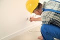 Male electrician inserting plug into socket in order to check its serviceability Royalty Free Stock Photo