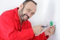 Male electrician installing electrical socket with screwdriver Royalty Free Stock Photo