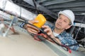 Male electrician repairing fire sensor