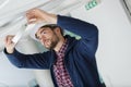 Male electrician with screwdriver repairing fire sensor Royalty Free Stock Photo