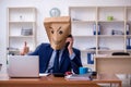 Young male employee with box instead of his head Royalty Free Stock Photo