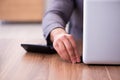 Young male employee inserting flash drive into laptop