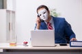 Male employee with mask in hipocrisy concept Royalty Free Stock Photo