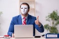Male employee with mask in hipocrisy concept Royalty Free Stock Photo
