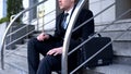 Male employee sitting on office building stairs, work problem, bankruptcy