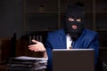 Male employee stealing information in the office night time Royalty Free Stock Photo