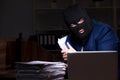 Male employee stealing information in the office night time Royalty Free Stock Photo