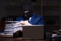 Male employee stealing information in the office night time Royalty Free Stock Photo