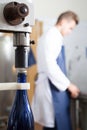 Male employee using machine to cork wine at sparkling wine factory Royalty Free Stock Photo