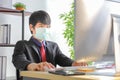 Male employee wearing medical face mask while working in the business office during coronavirus or covid-19 outbreak