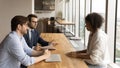 Male employers talk with female candidate at meeting