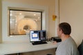 male engineer adjusts magnetic resonance imaging scanner