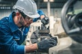 Male engineer in blue jumpsuit and white hard hat operating lathe machine. Royalty Free Stock Photo