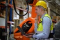 A male engineer checking the operation of a welding robot.