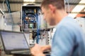 Male Engineer In Factory Using Laptop Computer