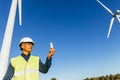 Male engineer holding a light bulb while standing in wind turbine field. Royalty Free Stock Photo