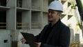 Male engineer looking at blueprints on a tablet at the active construction site Royalty Free Stock Photo