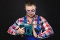 male engineer is looking at the camera while holding a tool. Satisfied master carpenter in goggles holds a large Royalty Free Stock Photo