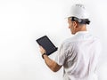 Male engineer in a white hard helmet. Middle-aged man in a white shirt with a tablet computer. Back view. Isolated portrait Royalty Free Stock Photo